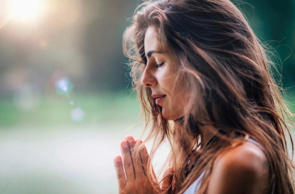 Frau bei einer achtsamen Meditation in der Natur während eines Mind Detox Retreats in der Eifel